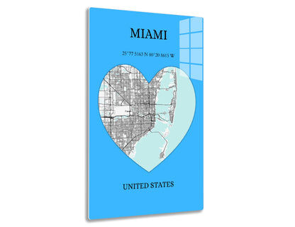 Map of Miami in the shape of a heart, showing the city streets in gray and surrounding coastal areas in blue, with text displaying the city's name, geographic coordinates, and country.
