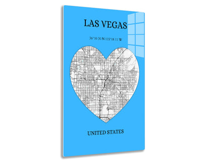 Street map of Las Vegas in the shape of a heart on a blue background, showing major roads and neighborhoods. Geographic coordinates 36°10'30"N 115°08'11"W are provided below the city name.
