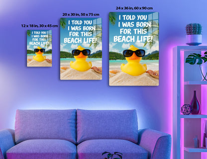 A yellow rubber duck wearing sunglasses sits on a beach, with the text "I told you I was born for this beach life!" against a backdrop of palm trees, mountains, and the ocean.
