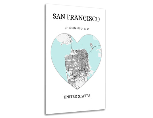 Map of San Francisco in the shape of a heart with street layout overlaid on aqua blue background, latitude and longitude coordinates provided below city name.
