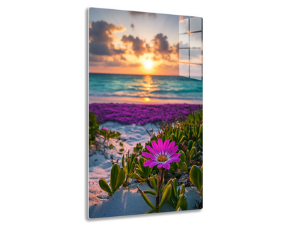 Vibrant sunset over the ocean with a purple flower field in the foreground and dramatic clouds reflecting on the rippled water surface.
